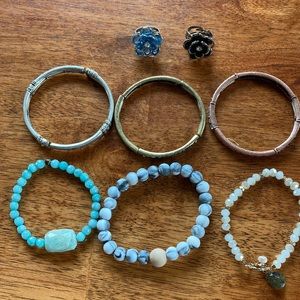 Two adjustable rings, and 5 bracelets. 3 are a set of different metals.